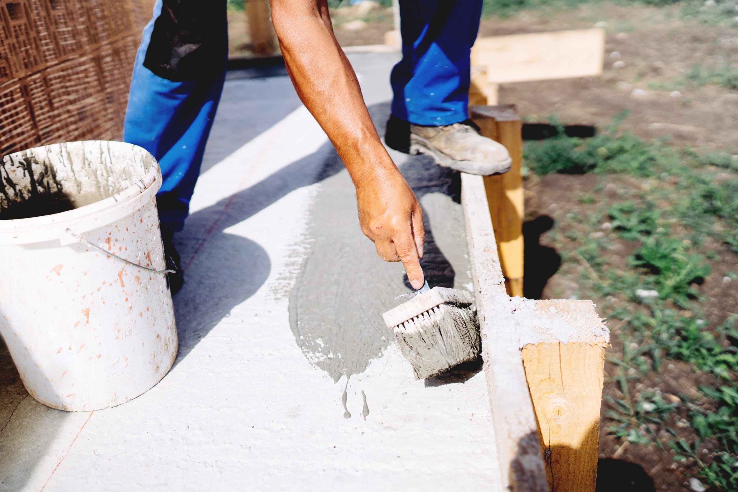 industry worker using brush and primer for hydroisolating and waterproofing house