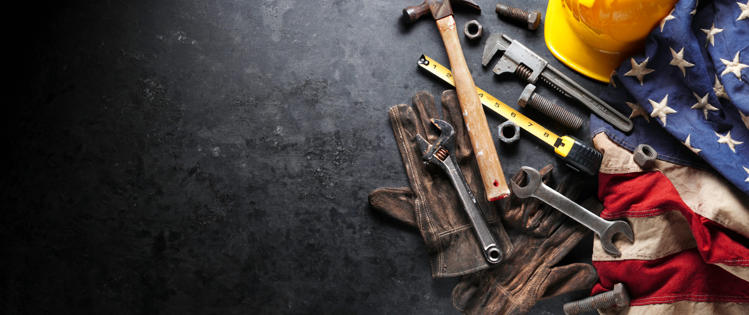 Image of tools and construction equipment and an American flag.