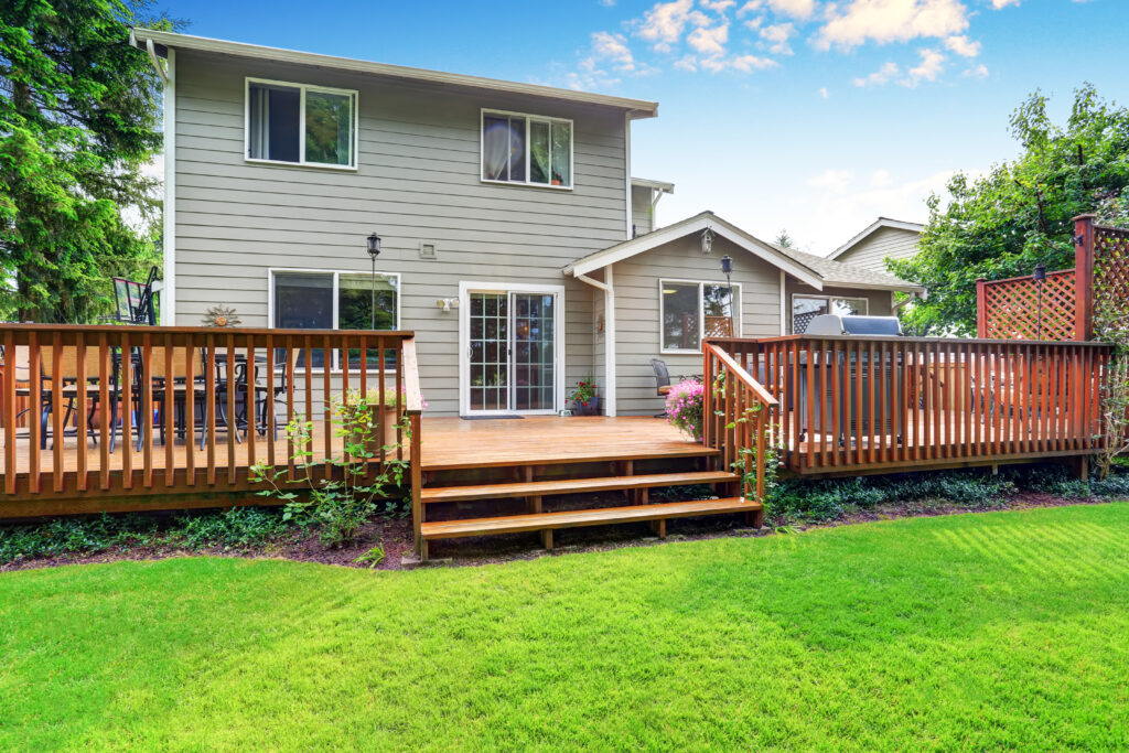 Image of the backyard of a house with a wooden deck