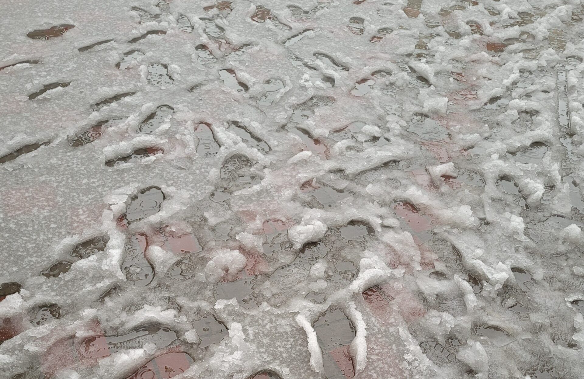 Footprints in melting snow on a sidewalk - What is Liquid Ice Melt blog image